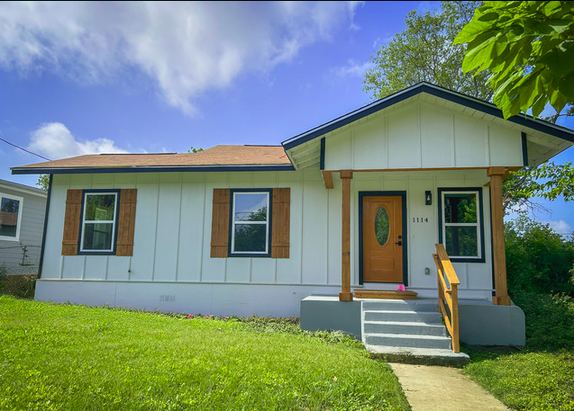 Front exterior of 1114 Pasadena, sage-green single-story home with red door