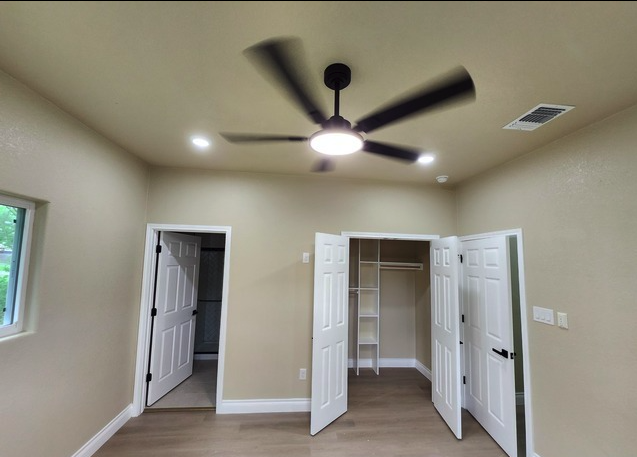 Bedroom with double-door closet and ceiling fan
