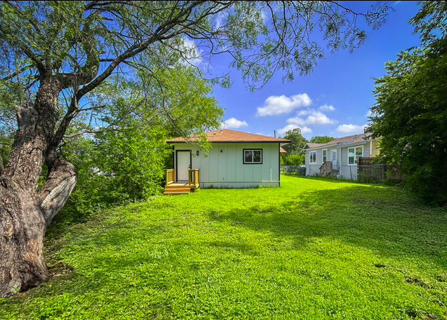 Fenced backyard with mature shade tree and detached storage