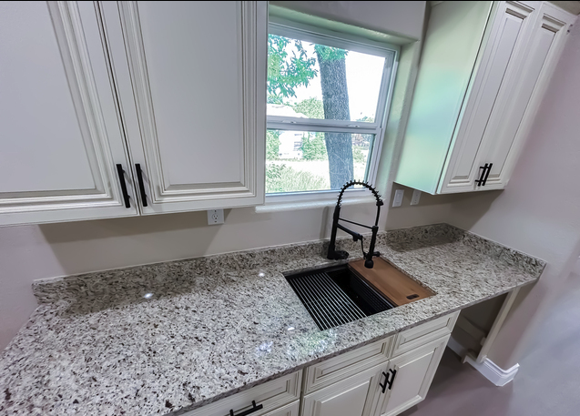 Kitchen with white shaker cabinets, granite counters, and undermount sink