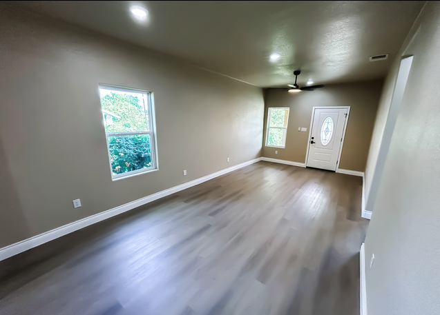 Living room with vinyl plank flooring and natural light